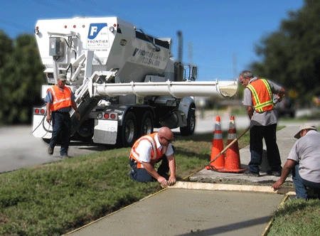 Ready mix truck pouring concrete for sidewalk